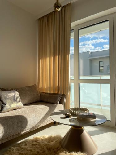 a living room with a couch and a large window at Apartament Echo Park in Olecko