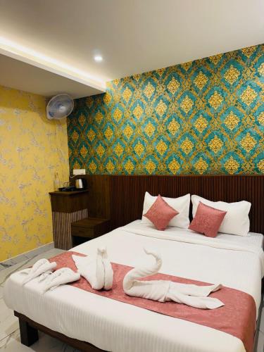 a hotel room with two beds with towels on them at Laalis Crest in Madikeri
