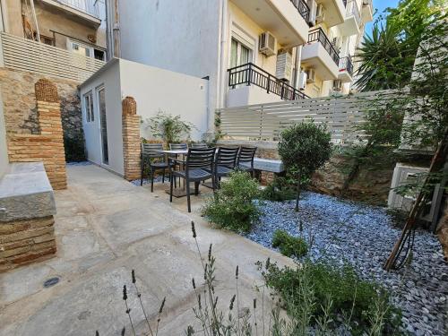 a patio with a table and chairs in front of a building at Silk Suites by YHA in Athens
