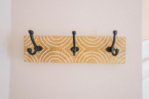 a towel hanging on a wall with three hooks at La Rosa dei Venti Guesthouse in Villasimius