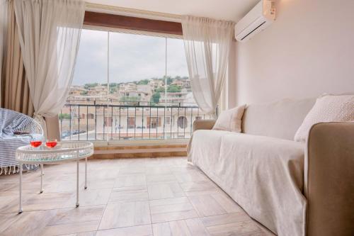 a living room with a couch and a large window at La Rosa dei Venti Guesthouse in Villasimius
