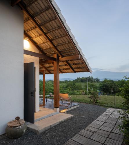 a patio with awning and a table and chairs at Thiime - Chiang Rai in Ban Doi Hang