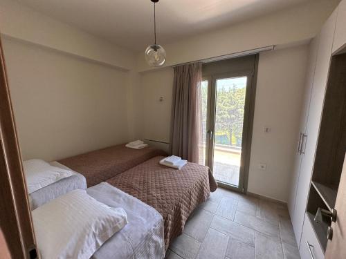 a hotel room with two beds and a window at SeaSide Village in Politiká