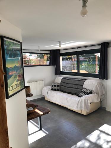 - un salon avec un grand lit et des fenêtres dans l'établissement Appartement Rez de jardin 1 à 4 pers - 2 chambres, à Collobrières