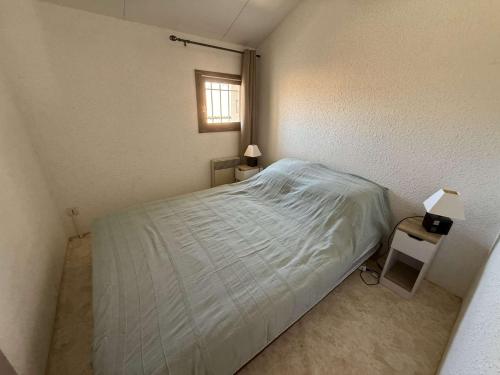 une petite chambre avec un lit et une fenêtre dans l'établissement Jolie maison dans résidence sécurisée avec piscine commune , 4 couchages , 400 m de la plage de PORTIRAGNES PLAGE LRJP54, à Portiragnes