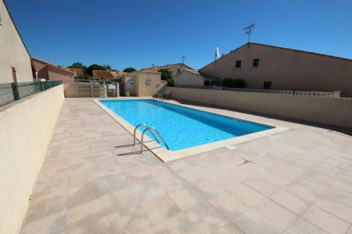 - une piscine sur le côté d'une maison dans l'établissement Jolie maison dans résidence sécurisée avec piscine commune , 4 couchages , 400 m de la plage de PORTIRAGNES PLAGE LRJP54, à Portiragnes