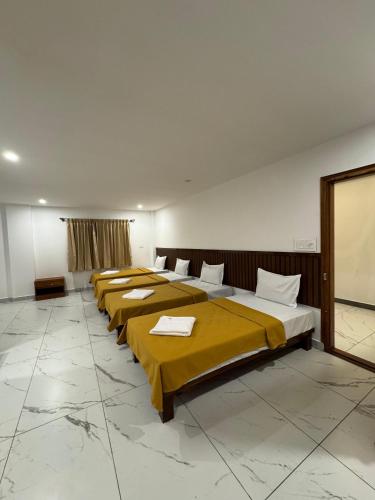 a row of beds lined up in a room at Laalis Crest in Madikeri