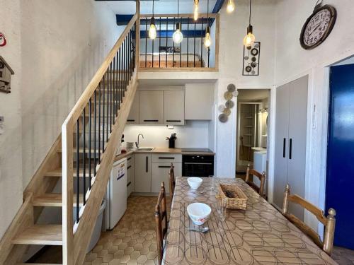 une cuisine avec une table à manger et un escalier dans l'établissement Appartement cosy avec mezzanine, 6 couchages, à 500m de la mer - St Cyprien - FR-1-225D-168, à Saint Cyprien Plage