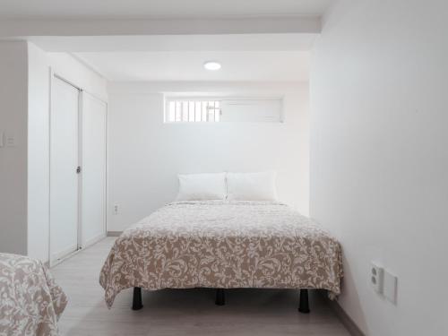 a white bedroom with a bed and a window at SeogyoHueStay in Seoul