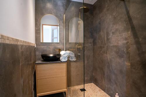 une salle de bain avec une douche avec un lavabo et un miroir dans l'établissement Le Loft de Souhey, à Souhey