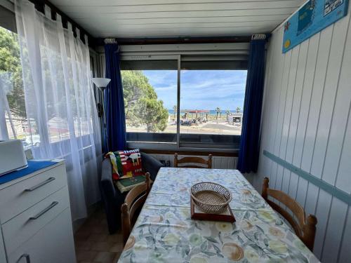 une salle à manger avec une table et une fenêtre dans l'établissement Appartement cosy avec loggia, proche plage & centre, 4 couchages à Saint-Cyprien - FR-1-225D-201, à Saint-Cyprien