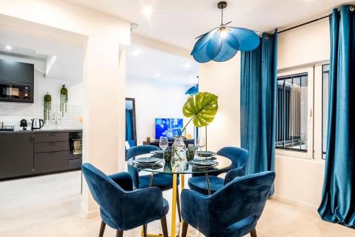 une salle à manger avec une table en verre et des chaises bleues dans l'établissement Keyz - Central 2 Bedrooms near the Picasso Museum, à Paris