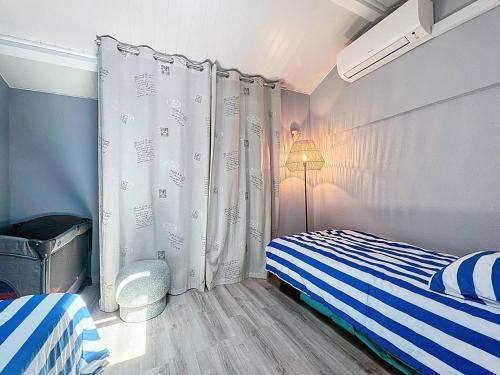 - une chambre avec un lit bleu et blanc et une lampe dans l'établissement Appartement à Saint-Cyr-sur-Mer proche plage avec clim et parking privé - FR-1-770-45, à Saint-Cyr-sur-Mer