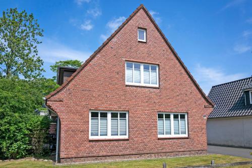a red brick house with white windows at Ferienhaus Neumann in Heide