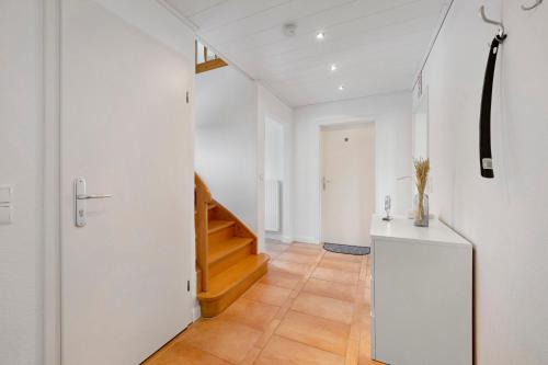 a hallway with white walls and a staircase in a house at Ferienhaus Neumann in Heide