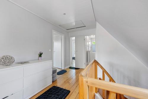 a hallway with white walls and a wooden staircase at Ferienhaus Neumann in Heide