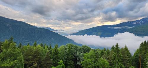 - une vue sur une vallée avec des nuages et des montagnes dans l'établissement Belvédère Relais Motos, à Séez