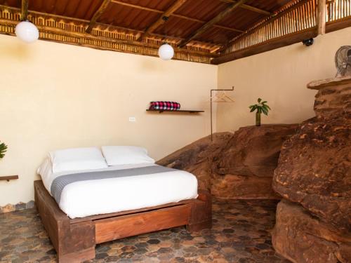 a bedroom with a bed in a room with rocks at REFUGIO LA ROCA in Los Santos