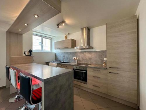 - une cuisine avec un comptoir et quelques chaises dans l'établissement Le logis du chevalier saint-jean, au Puy-en-Velay