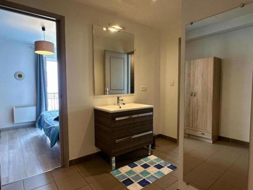 une salle de bain avec un lavabo et un miroir dans l'établissement Le logis du chevalier saint-jean, au Puy-en-Velay