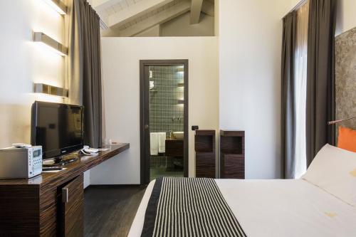 a hotel room with a bed and a television at Hotel Ancora in Verbania