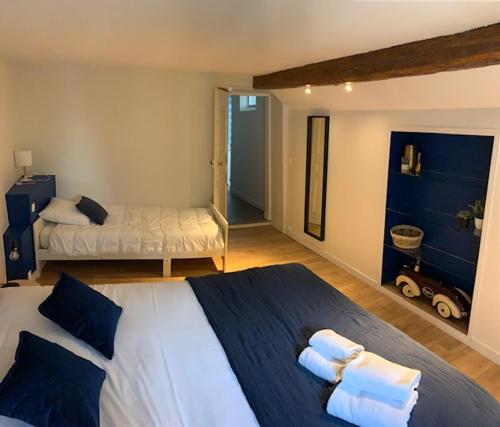 a bedroom with a large bed with towels on it at La Maison d'Emilie - Chambres d'hôtes in Chaumes-en-Brie