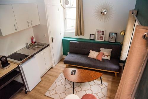 un petit salon avec un canapé et une table dans l'établissement Duplex sur cour, Rue Caponière, à Caen