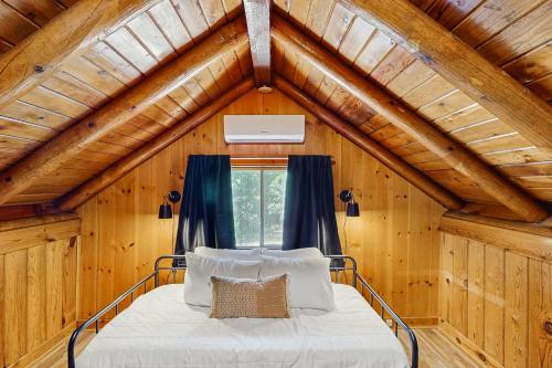 a bed in a room with a wooden ceiling at Cowboy Cabin in Pinetop-Lakeside