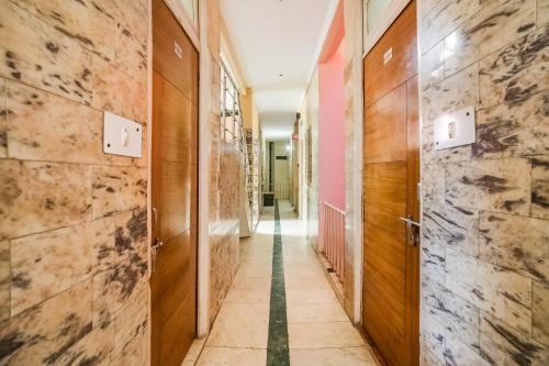 a corridor with wooden doors and marble walls at Hotel Silver Palace in New Delhi
