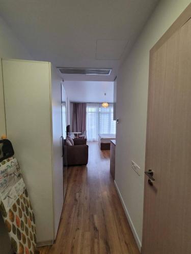 a hallway with a door and a living room at Luxury Suites White Sails in Batumi