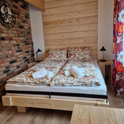 a bed in a room with a brick wall at CICHY ZAKĄTEK - noclegi blisko Termy Chochołowskie in Ciche