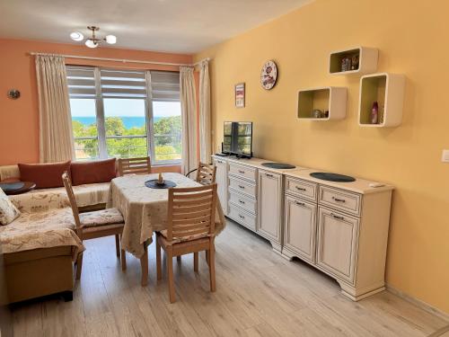 a kitchen with a table and a dining room at Sea View Apartment in Aurora Complex, Steps from the Beach in St. St. Constantine and Helena