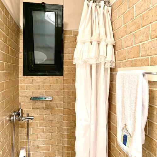 a bathroom with a white shower curtain and a mirror at Κ2 VILLA from k2properties in Pefkochori