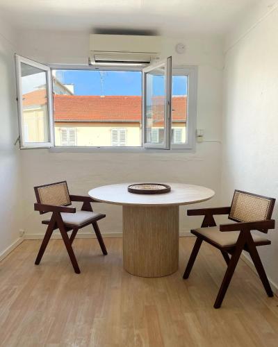 une pièce vide avec une table et deux chaises dans l'établissement Chic studio Palais 2 min away, à Cannes