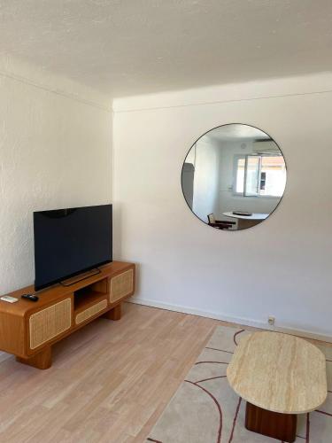 - un salon avec une télévision et un miroir dans l'établissement Chic studio Palais 2 min away, à Cannes