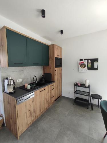 a kitchen with wooden cabinets and a black counter top at Nowa Osada in Łącko