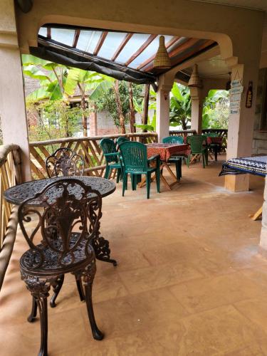 a patio with tables and chairs on a porch at Edaala Comfort - B&B in Nairobi