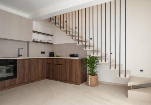 a kitchen with wooden cabinets and a staircase at Vista Luxury Suites in Neos Marmaras