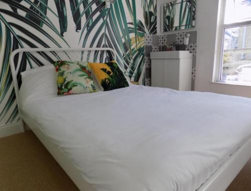 a white bed with two pillows in a bedroom at Sea Bed Guesthouse in Newquay