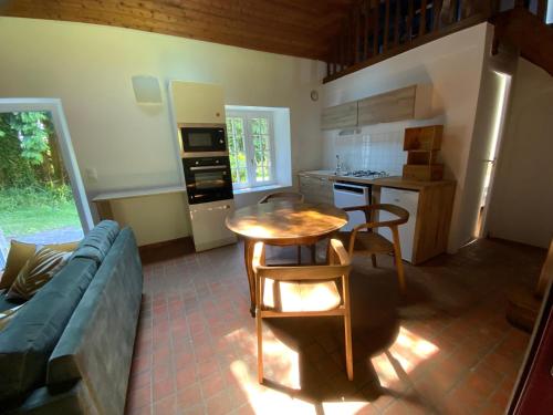 un salon avec une table et une cuisine dans l'établissement Penty entre campagne et Océan, à Audierne
