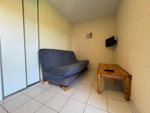 a room with a blue couch and a table at La Vallée Appartement 36 - Thermes Neyras les Bains in Meyras