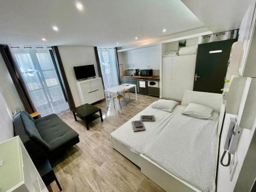 une petite chambre avec un lit et une cuisine dans l'établissement Dolaizon 2 - Studio Meublé 28 M2, au Puy-en-Velay
