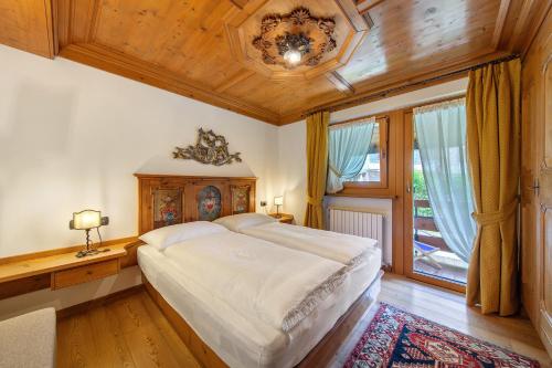 une chambre avec un grand lit avec un plafond en bois dans l'établissement Hilde's House, à Peaio