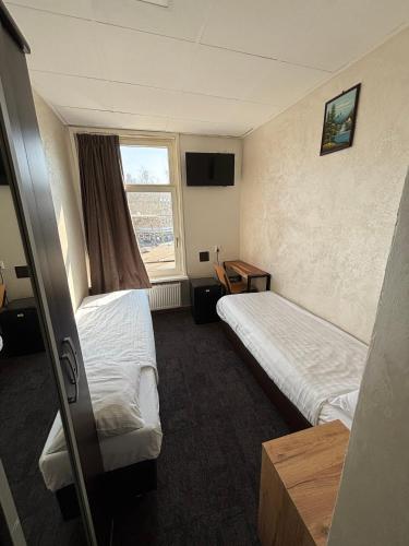 a hotel room with two beds and a window at Flex-Inn in Rotterdam