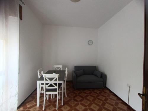 a room with a table and a chair and a couch at Azzurra Haven in Berchidda