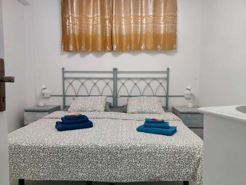 a bedroom with a bed with two blue towels on it at Joy & Friends 1 in Los Cristianos