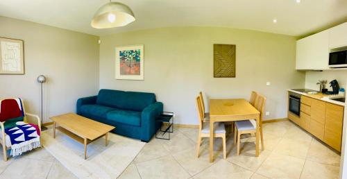 un salon avec un canapé bleu et une table dans l'établissement Le Prieuré de Saint Broing, 