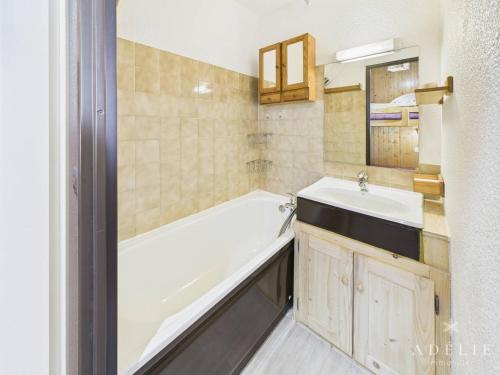 une salle de bain avec une baignoire et un lavabo dans l'établissement Studio cabine 4/5 pers, balcon exposé sud, à 50m des pistes, parking inclus - FR-1-398-513, à La Rosière