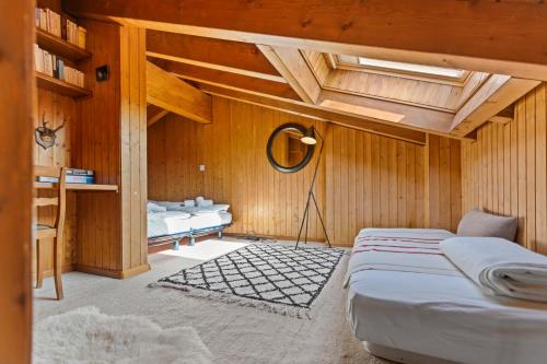 克莱恩 蒙塔纳Piscine, Ski & Vue sur le lac - Crans 6 pers的一间带两张床铺的卧室,位于带木墙的房间内