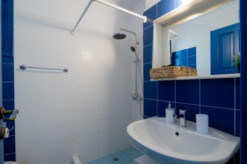 a blue and white bathroom with a sink and a mirror at Traditional Cycladic Home Paros in Naousa